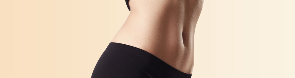 extreme close up of woman exposed thin stomach with off white background